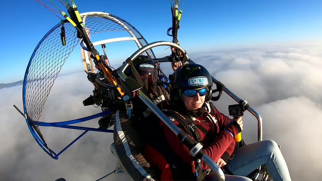 Pasajera feliz en un vuelo en paramotor sobre un mar de nubes simbolizando el mejor paramotor precio para una experiencia biplaza.