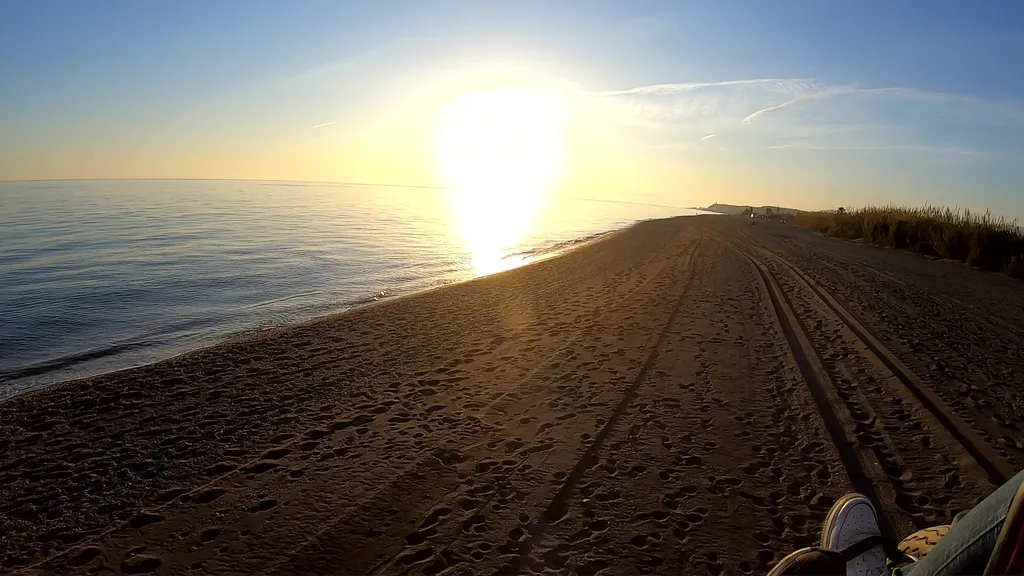 Vista desde un paramotor en una playa de arena durante la salida del sol como parte del paramotor precio
